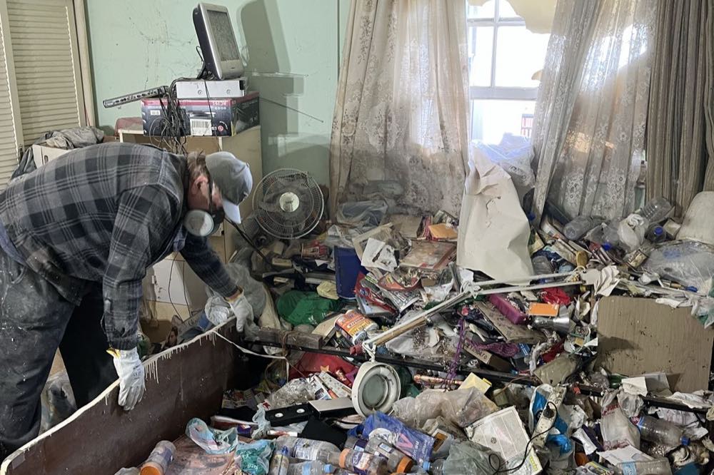One of our crew working through a severely hoarded bedroom on a real Sydney job