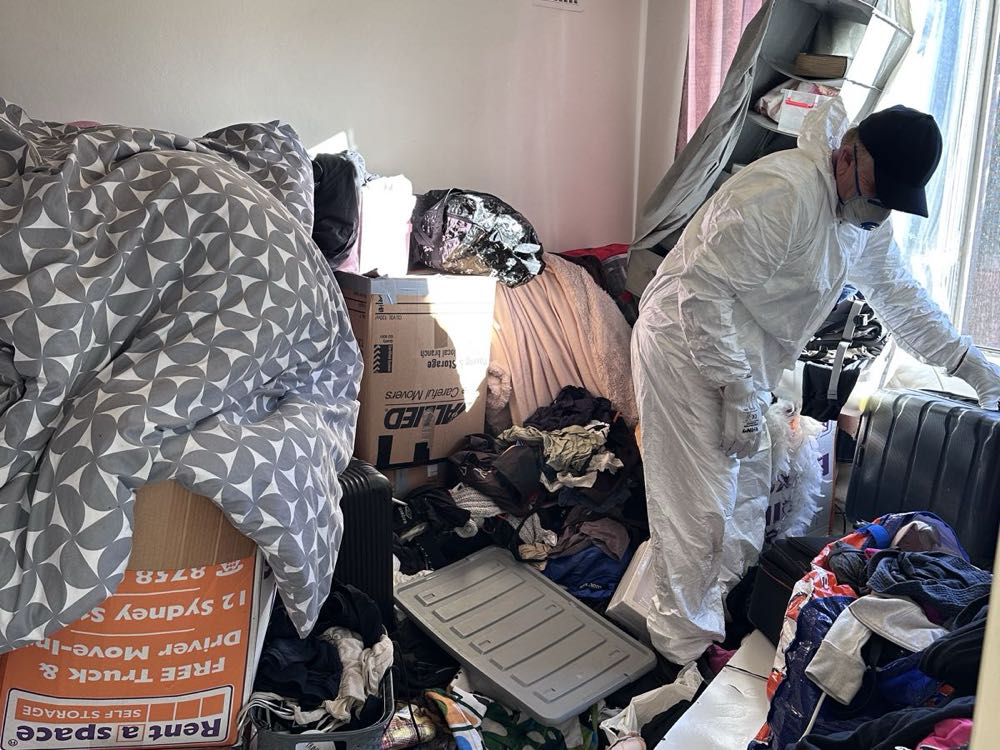 One of our crew sorting a hoarded bedroom on a real Hoarder Cleanup job