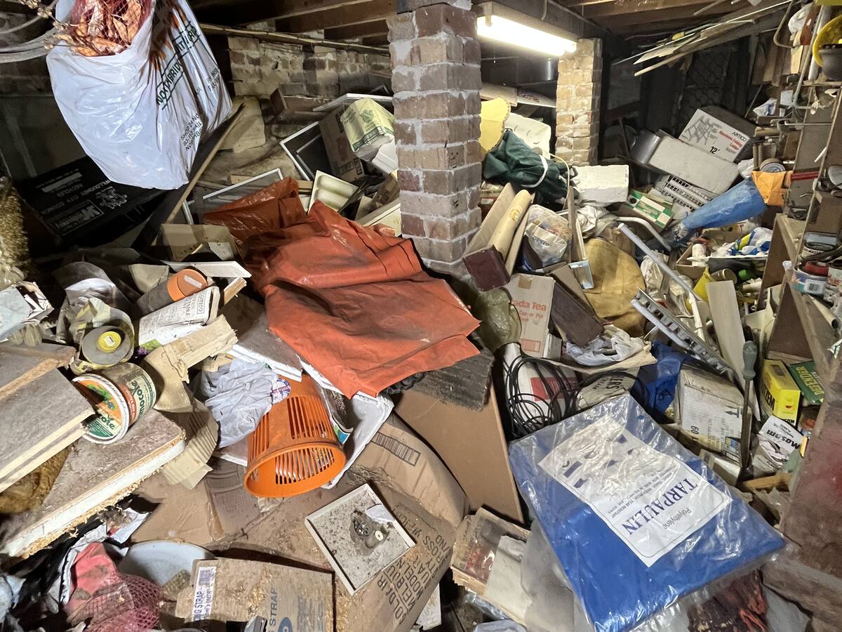 An under house storage space packed with belongings before a clean out, a real job